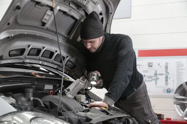 Mécanicien en atelier effectuant un diagnostic d'entretien automobile